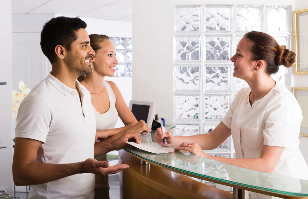 Young european couple patients visiting clinic family planning front desk