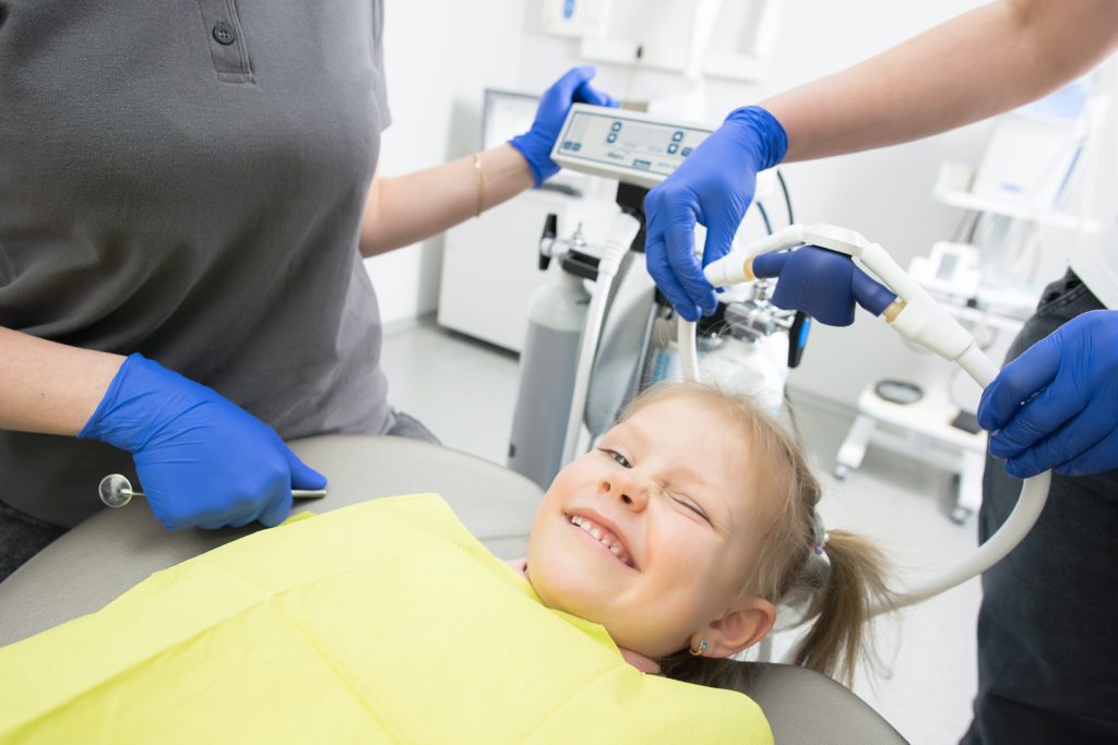 A child winking in a dental chair.