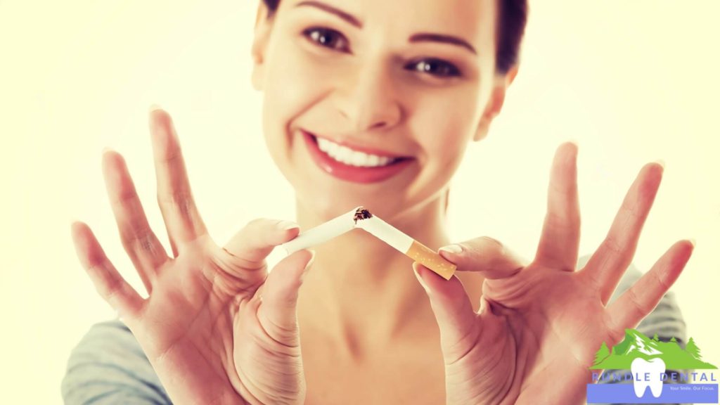 A woman breaking a cigarette in half.